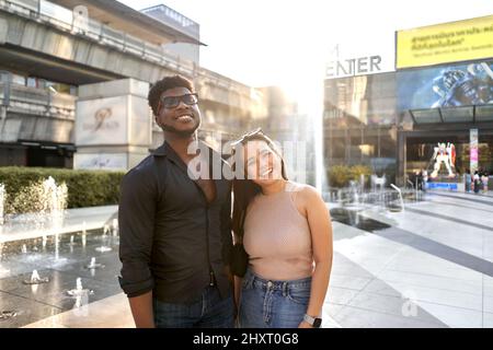 Porträt zweier multirassischer Freunde, die lächeln und in einem Einkaufszentrum stangeln Stockfoto