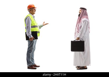 Reifer männlicher Bauingenieur, der ein Gespräch mit einem saudischen Geschäftsmann auf blauem Hintergrund geführt hat Stockfoto