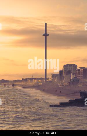 Brighton, East Sussex, England. 13. März 2022. Die Sonne geht an einem frühen Frühlingsabend in Brighton unter, wobei die i360 vom Pier aus über das Meer gesehen werden.©Sarah Mott / Alamy Live News Stockfoto