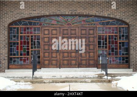 Symmetrische Aufnahme der Fassade einer Kirche mit Holztüren und Buntfenstern in Hespeler, Kanada Stockfoto