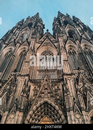 Vertikale Low-Angle-Aufnahme der Kölner Domfassade unter dem klaren Himmel in Köln Stockfoto