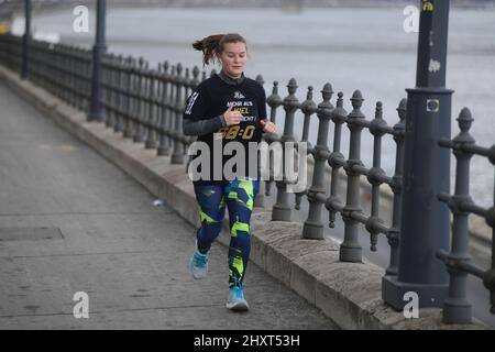 Frau, die im Winter am Donauufer läuft. Budapest. Ungarn Stockfoto