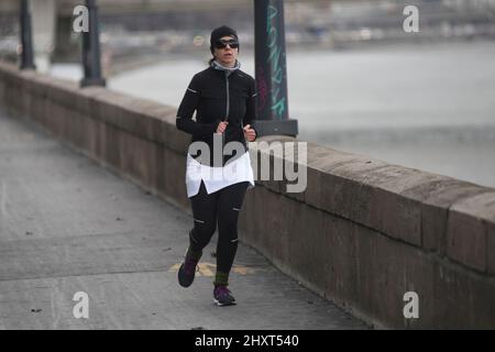 Frau, die im Winter am Donauufer läuft. Budapest. Ungarn Stockfoto