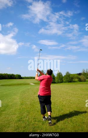 Mann spielt Golf an einem heißen Sommertag. Stockfoto