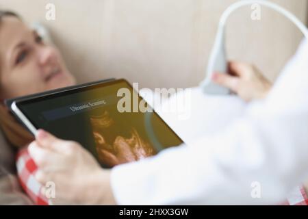 Arzt, der Ultraschall-Untersuchung der Patienten Bauch in der Klinik, qualifizierter Arzt Stockfoto