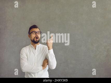 Intelligenter selbstbewusster kaukasischer Mann, der eine große innovative Idee hat, die ein Finger eureka Zeichen zeigt. Stockfoto