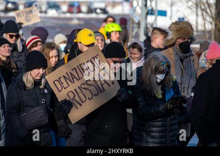 Denazificate Russland! Demonstranten mit einem Pappschild auf dem marsch zur russischen Botschaft in Helsinki, Finnland. Stockfoto