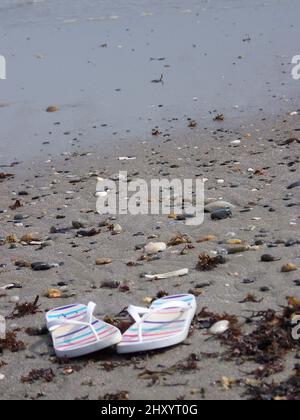 Vertikale Aufnahme von Flip Flops an einem Kieselstrand in Narragansett, Washington County, Rhode Island, USA Stockfoto