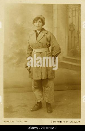 Originalpostkarte aus der Zeit WW1 von Fabrikarbeiterin, Munitionsarbeiterin, mit Hose und Mütze, Studio of American Gallerie, 259 Argyle St. Glasgow, um 1916-1918. Stockfoto