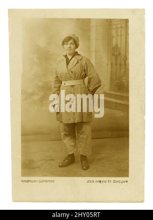 Originalpostkarte aus der Zeit WW1 von Fabrikarbeiterin, Munitionsarbeiterin, mit Hose und Mütze, Studio of American Gallerie, 259 Argyle St. Glasgow, um 1916-1918. Stockfoto