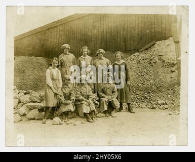 Originalfoto aus der Zeit von WW1 von einer Gruppe weiblicher Steinbrucharbeiterinnen, die die Arbeit von Männern verrichten, die im Krieg gekämpft haben. Die Mädchen tragen Uniform und sitzen zwischen Steinbrüchen. Runcorn, Khishire, Großbritannien, um 1916. Stockfoto