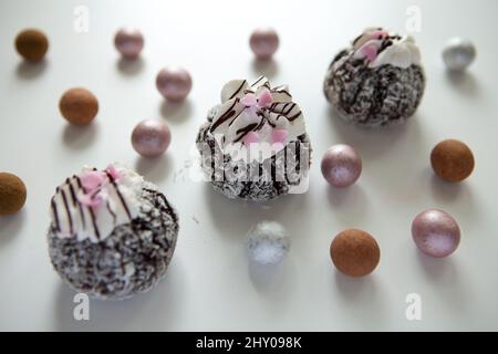 Kuchen Rum Trüffel Kugeln mit Kokosnuss und Herzen Süßigkeiten auf weißem Hintergrund Stockfoto