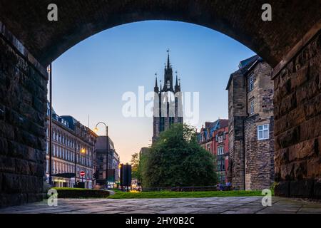 Blick auf die Cathedral Church of St. Nichola Rahmen durch einen Tunnel in der Nähe des Newcastle Castle in der Abenddämmerung in England Stockfoto