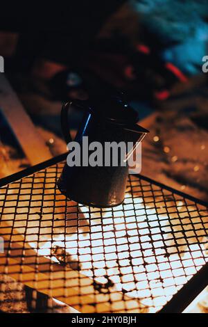 Kaffee- oder Teekocher auf einem Gitter am Lagerfeuer Stockfoto