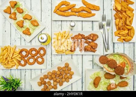 Set mit zerschlagten frittierten Hühnergerichten, Nuggets, Kartoffelkeilen, Falafel-Sandwich, Kroketten, Gebratene Hähnchenstreifen, Flügel mit Kartoffeln, Zwiebelringe und Stockfoto