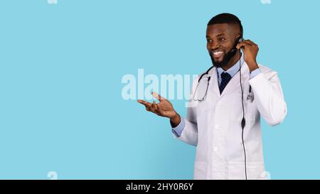 Online-Beratung. Lächelnder Schwarzer Arzt Trägt Headset Und Spricht Mit Dem Patienten Stockfoto