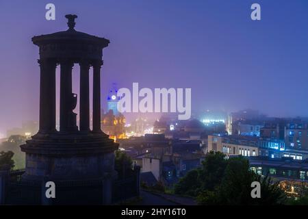 Calton Hill Blick auf die Stadt an einem nebligen Abend in Edinburgh, Schottland Stockfoto