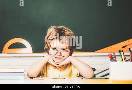 Schüler lernen Buchstaben und Zahlen. Kinder machen sich bereit für die Schule. Zu Hause Schulbildung. Freundliches Kind im Klassenzimmer in der Nähe der Tafel. Talentiertes Kind. Kind Stockfoto