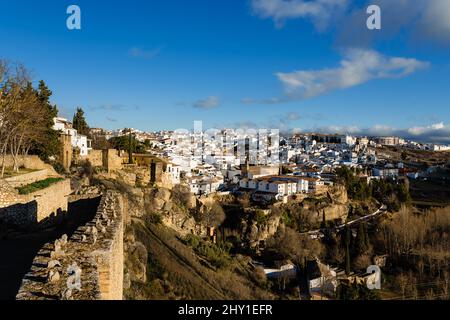 Malerische Landschaft der kleinen Stadt mit typischen weißen Häusern und alten Steinfestungen gegen den wolkigen blauen Himmel in Ronda Stockfoto