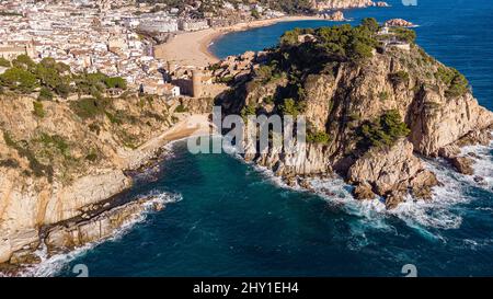 Luftaufnahme einer alten Stadt mit Wohnhäusern an der Küste in der Nähe von Wellenmeer bei Tageslicht in Spanien Stockfoto