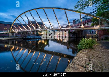 Abendansicht der Merchants Bridge, einem Wahrzeichen am Fluss im historischen Castlefield-Viertel von Manchester England Stockfoto