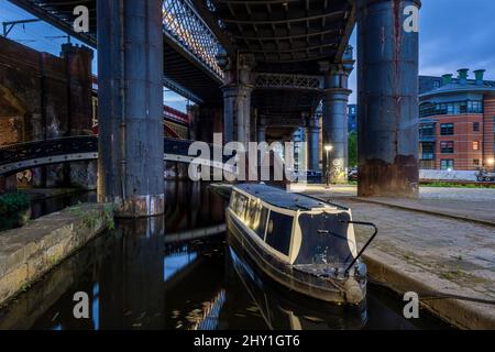 Am Abend dockten Brücken, Kanäle und ein Boot in der berühmten Gegend von Castlefield in Manchester an Stockfoto