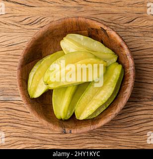 Starfruits in einer Schüssel über einem Holztisch. Stockfoto