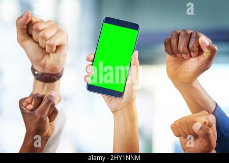 Einführung unseres neuen Geschäfts. Eine kurze Aufnahme einer Gruppe von Geschäftsleuten, die in einem modernen Büro jubelten und ein Mobiltelefon in der Hand hielten. Stockfoto