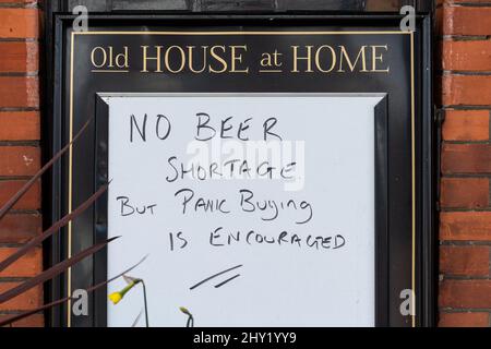 Amüsantes Schild vor dem Old House at Home Pub in Overton Village, Hampshire, England, Großbritannien. Es gibt keinen Biermangel, aber es wird Panik ausgelöst. Stockfoto