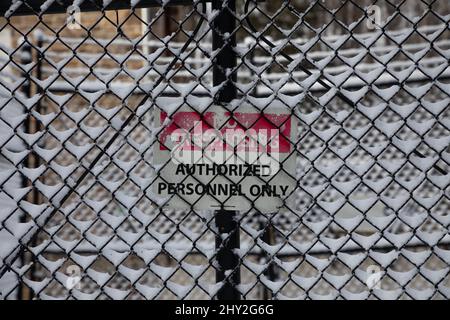 Kein Hinweisschild auf verschneiten Metallzaun Stockfoto