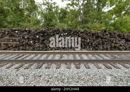 Neben aktiven Gleisen stapelten sich braune Eisenbahnverbindungen Stockfoto