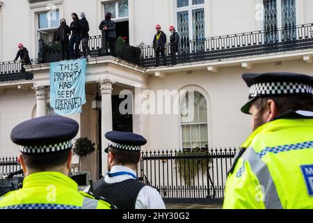 London, Großbritannien. 14. März 2022. Polizeibeamte, die im Londoner Mansion eines russischen Oligarchen gesehen wurden, das aus Protest gegen die russische Invasion der Ukraine von Antikriegsdemonstranten besetzt wurde. Demonstranten der Londoner Machnovisten übernahmen das Town House des russischen Oligarchen, Milliardär Oleg Deripaska, eines Verbündeten des russischen Präsidenten Wladimir Putin, das nach ihrer Aussage zur Unterbringung ukrainischer Flüchtlinge genutzt werden sollte. Kredit: SOPA Images Limited/Alamy Live Nachrichten Stockfoto