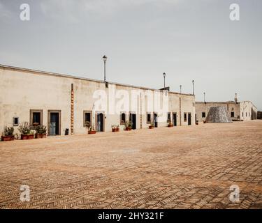 Perspektivische Aufnahme eines einstöckigen Gebäudes mit den gleichen Türen und Witwen. Stockfoto