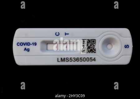 Positiver Covid 19 Lateral Flow Test / Rapid lateral Flow Antigen Coronavirus Test auf schwarzem Hintergrund mit beiden Balken auf dem Teststreifen Stockfoto