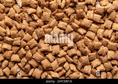 Vollformat-Hintergrund mit einer Reihe von Kissen Müsli gefüllt mit Schokolade. Maispads mit Schokoladenfüllung, oben. Stockfoto