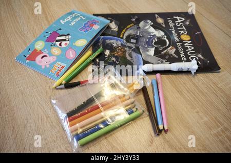 Nahaufnahme des Sets von Holzstiften, Peppa Pig, Buch über das Universum auf einem Holztisch. Stockfoto