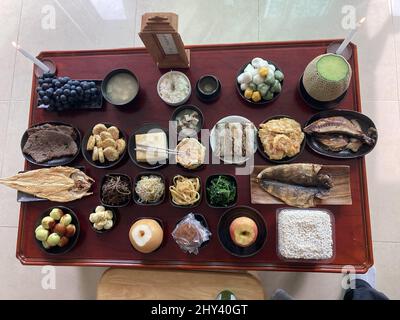 Verschiedene Obstsorten mit japanischen und koreanischen Gerichten auf einem Tisch Stockfoto