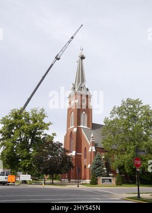 Baukran und Arbeiter reparieren den Kirchturm an einer Kirche in Missouri Stockfoto