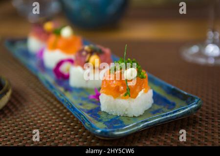 Köstlicher Premium-Lachs- und Thunfisch-Oshizushi-Sushi (Biera-Sushi) auf einem dekorierten handgefertigten Porzellanteller. Stockfoto