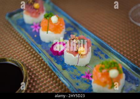 Köstlicher Premium-Lachs- und Thunfisch-Oshizushi-Sushi (Biera-Sushi) auf einem dekorierten handgefertigten Porzellanteller. Stockfoto