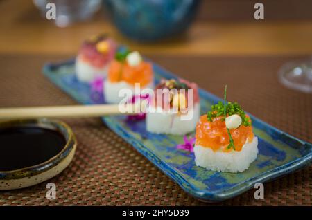 Köstlicher Premium-Lachs- und Thunfisch-Oshizushi-Sushi (Biera-Sushi) auf einem dekorierten handgefertigten Porzellanteller. Stockfoto