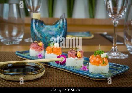 Köstlicher Premium-Lachs- und Thunfisch-Oshizushi-Sushi (Biera-Sushi) auf einem dekorierten handgefertigten Porzellanteller. Stockfoto