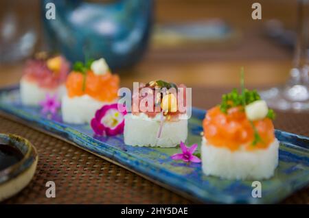 Köstlicher Premium-Lachs- und Thunfisch-Oshizushi-Sushi (Biera-Sushi) auf einem dekorierten handgefertigten Porzellanteller. Stockfoto