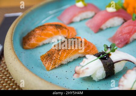 Verschiedene hochwertige Nigiri-Sushi-Gerichte mit Thunfisch und Lachs auf einem wunderschön dekorierten Teller. Stockfoto