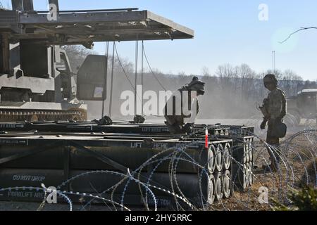 US-Soldaten, die der 41. Field Artillery Brigade zugewiesen wurden, laden M270 Multiple Launch Rocket Systems für eine Live-Feuerübung auf dem 7. Army Training Command's Grafenwoehr Training Area, Deutschland, 11. März 2022. Die Stationierung von US-Streitkräften ist hier eine umsichtige Maßnahme, die die kollektiven Ziele der NATO zur Kriegsprävention, die defensive Ausrichtung und das Engagement für den Schutz aller Alliierten untermauert. (USA Armeefoto von Gertrud Zach) Stockfoto