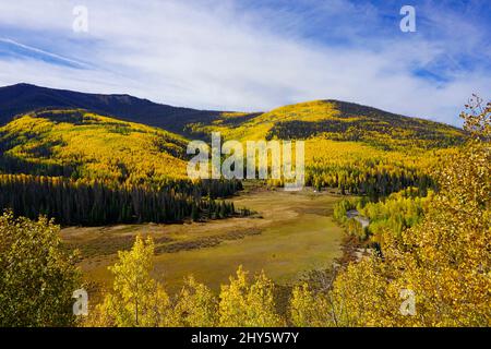 Aussichtspunkt am Highway 149 in Colorado mit Blick auf ein Tal, das von Bergen mit Herbstlaub umgeben ist. Stockfoto