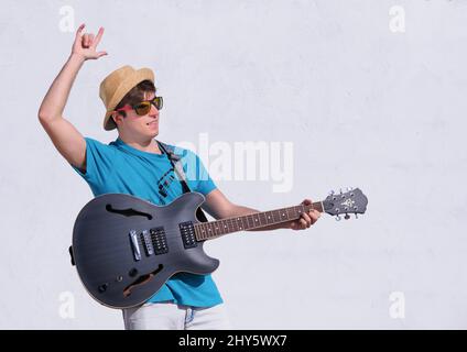 Junger kaukasischer Mann mit isolierter E-Gitarre auf weißem Hintergrund Stockfoto