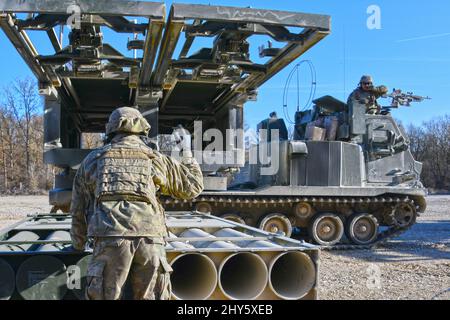 US-Soldaten, die der 41. Field Artillery Brigade zugewiesen wurden, laden M270 Multiple Launch Rocket Systems für eine Live-Feuerübung auf dem 7. Army Training Command's Grafenwoehr Training Area, Deutschland, 11. März 2022. Die Stationierung von US-Streitkräften ist hier eine umsichtige Maßnahme, die die kollektiven Ziele der NATO zur Kriegsprävention, die defensive Ausrichtung und das Engagement für den Schutz aller Verbündeten untermauert. (USA Armeefoto von Gertrud Zach) Stockfoto