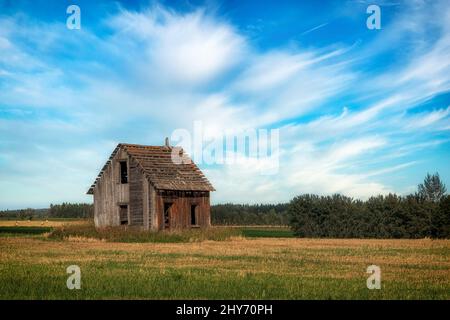 Ein altes, verlassenes Gehöft/Bauernhaus bei Sonnenuntergang in Alberta, Kanada. Stockfoto