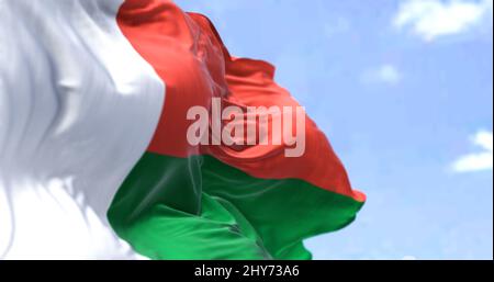 Detail der Nationalflagge Madagaskars, die an einem klaren Tag im Wind winkt. Madagaskar ist ein Inselstaat im Indischen Ozean. Selektiver Fokus. Stockfoto